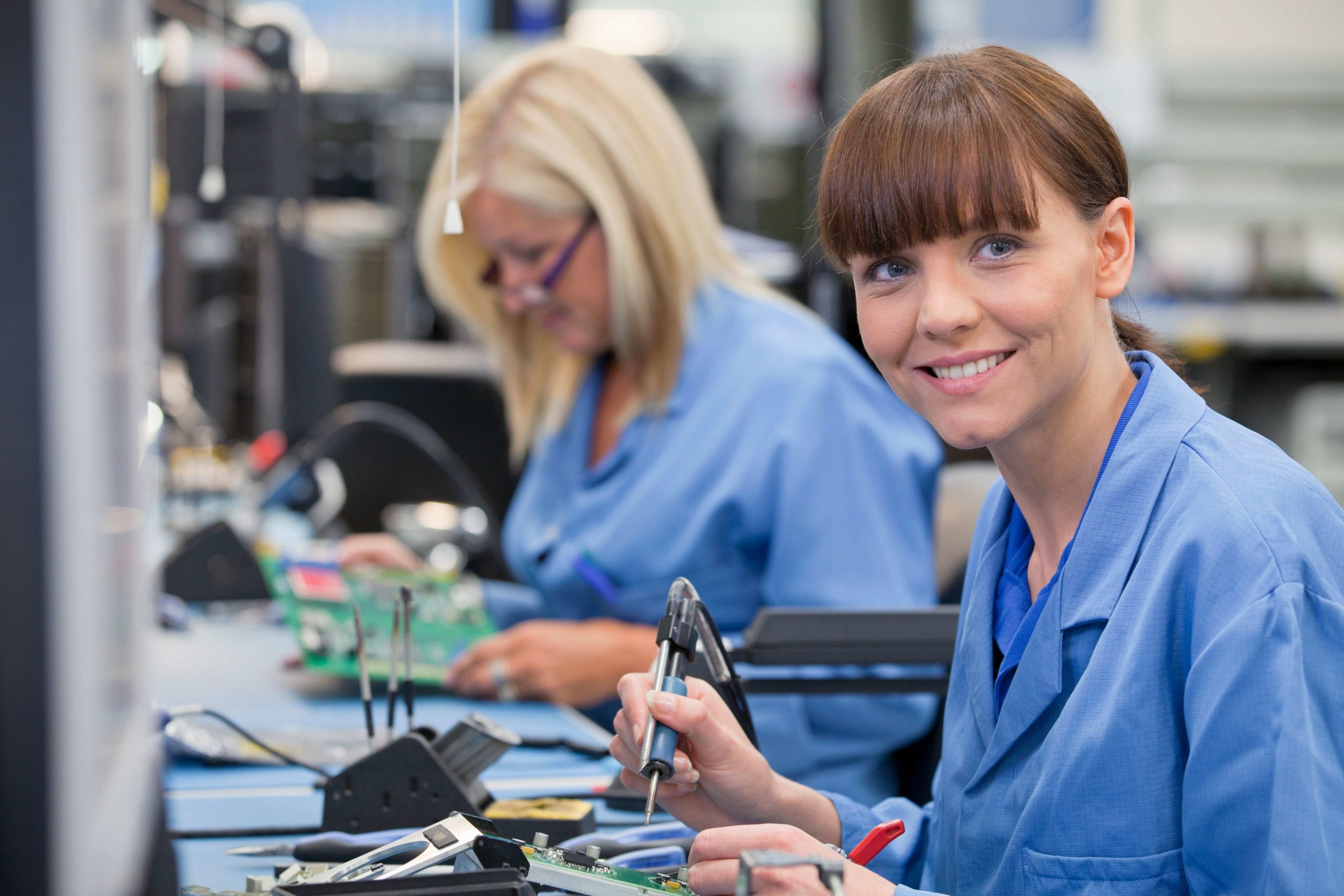 Horizontal,Profile,Shot,Of,A,Female,Technician,In,An,Assembly two women electrical engineers working on electrical parts in a factory