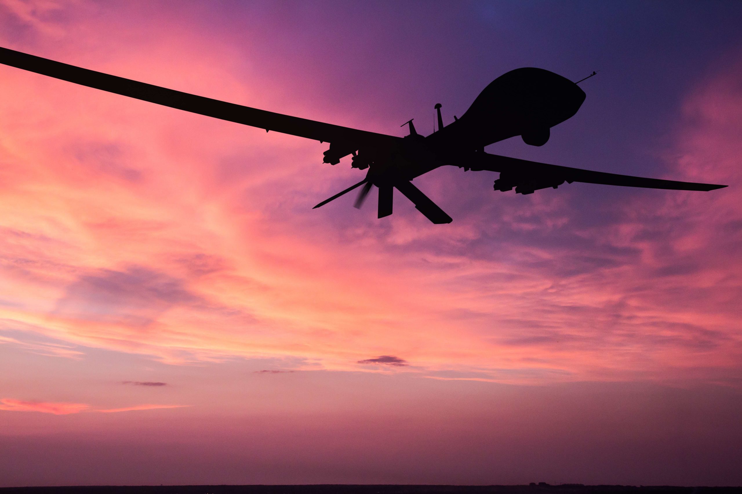 Military,Drone,Silhouette,On,Sunset,Background. a silhouette of an aircraft on a pink sky